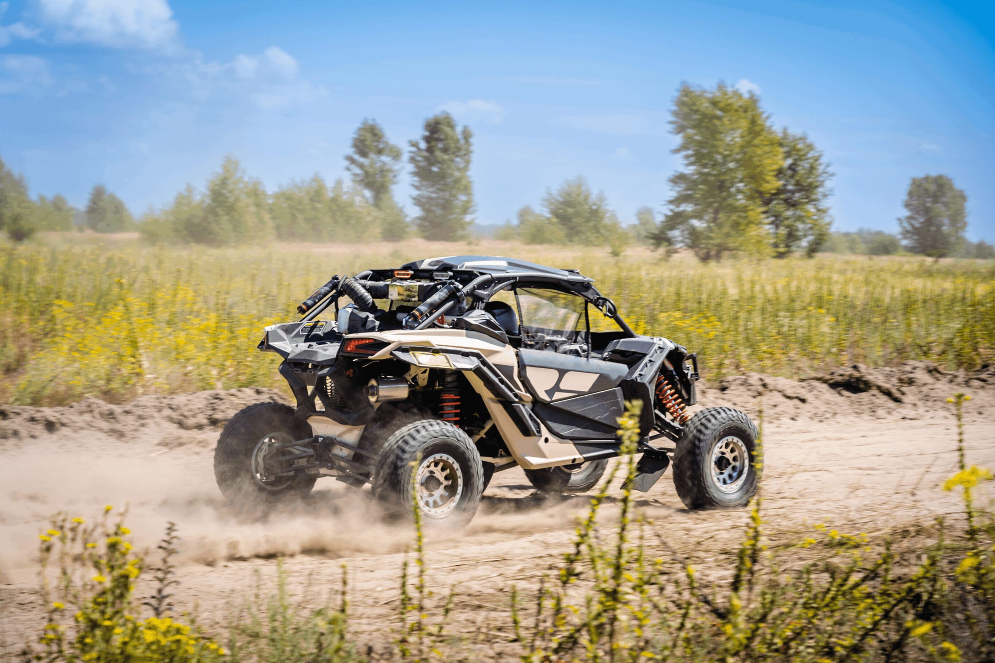 A black and silver vehicle is driving on the dirt.