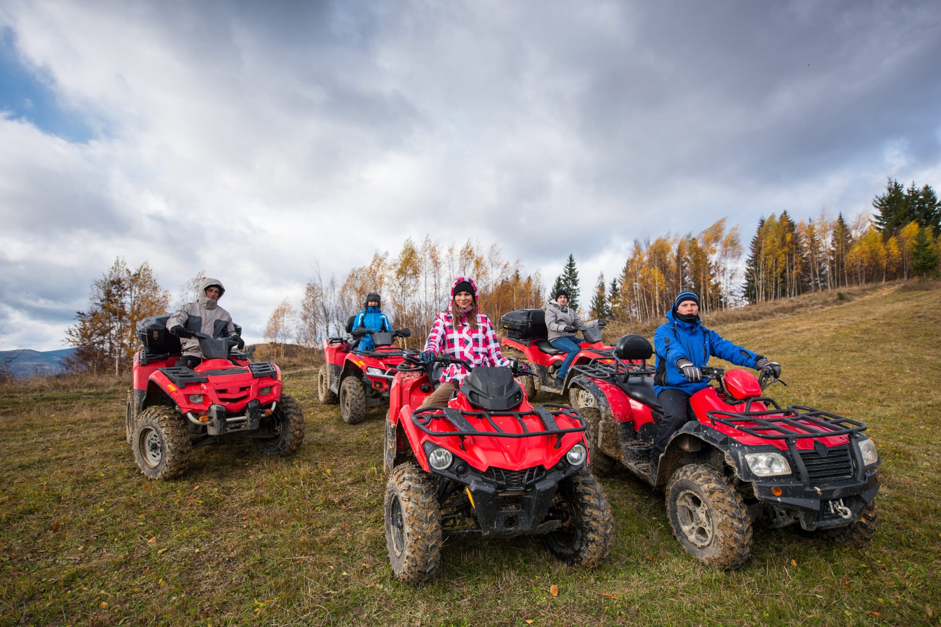 A group of people riding atvs on top of grass.
