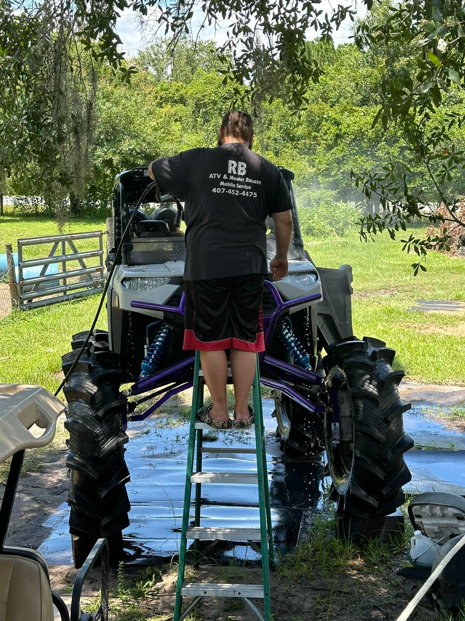 A man standing on the back of an atv.