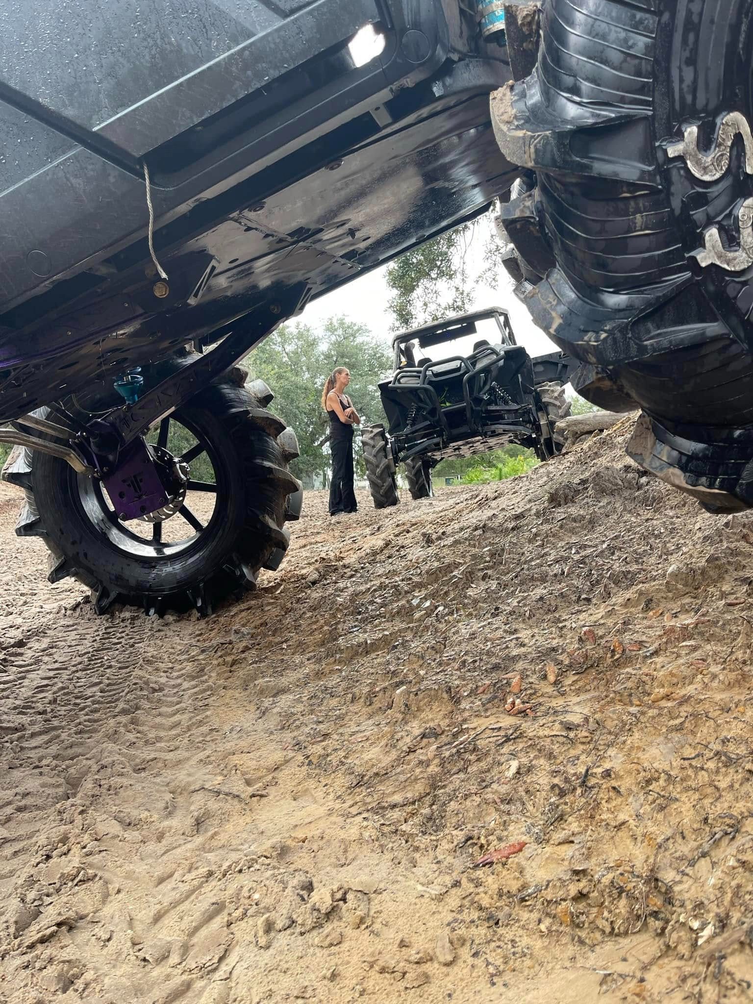 A person standing next to an off road vehicle.