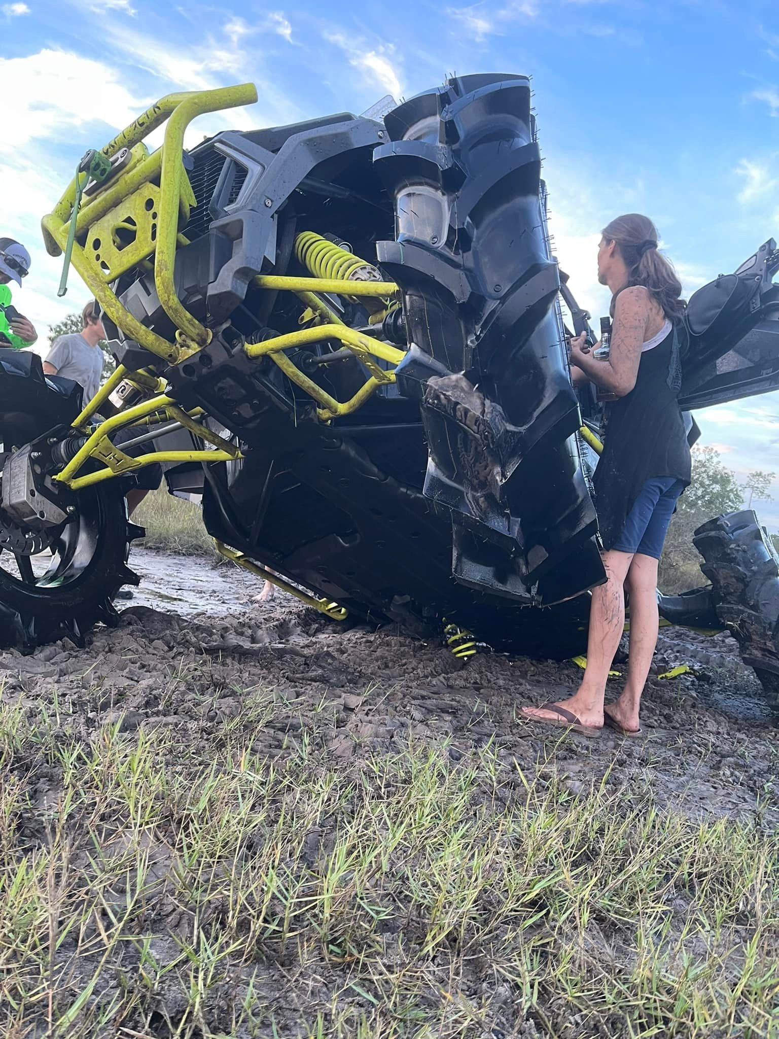 A person standing next to an atv that has been knocked over.