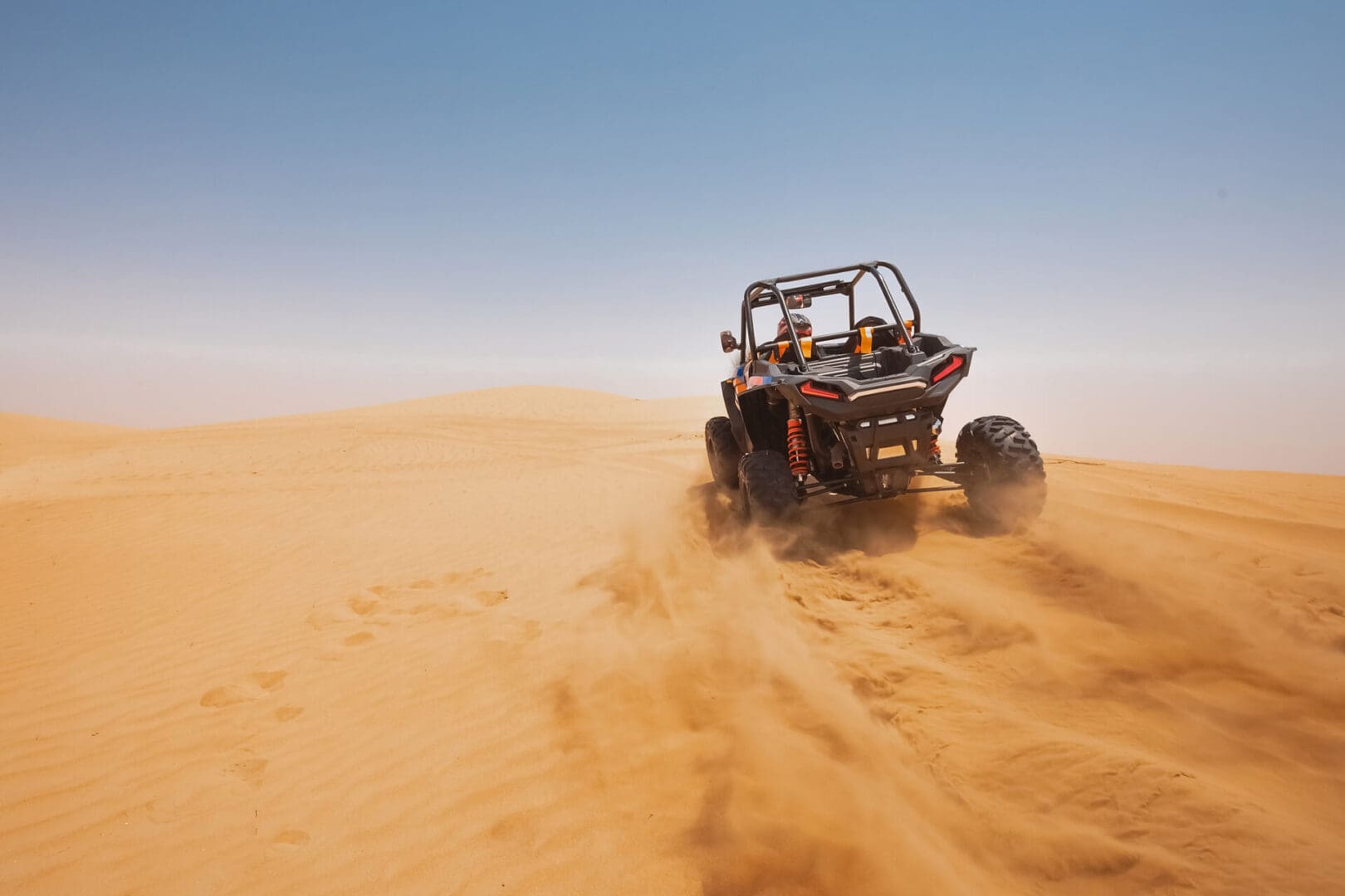 UTV driving across distant desert dunes