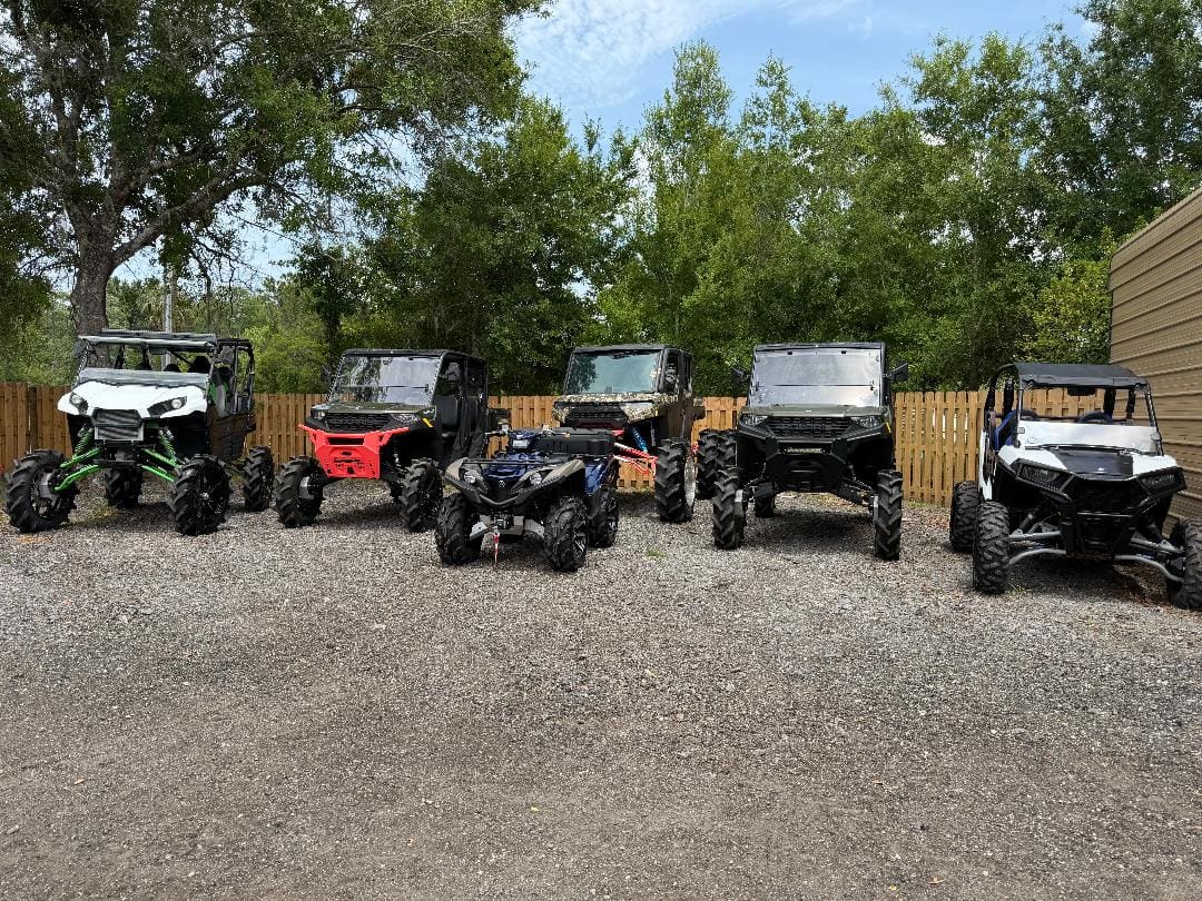Row of off-road UTVs and ATVs parked