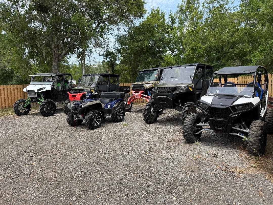 Several off-road ATVs and UTVs parked